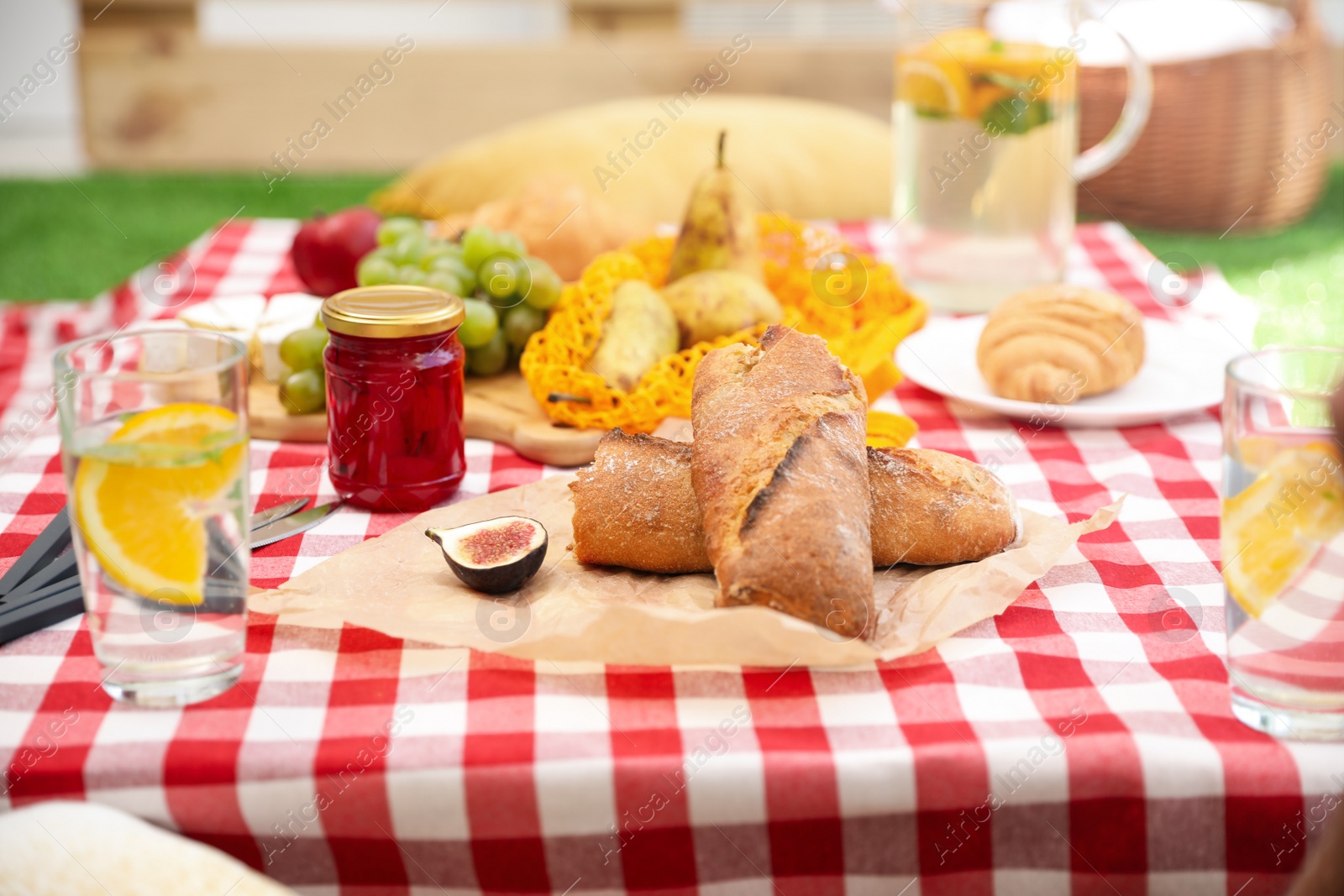 Photo of Different tasty food on picnic blanket, closeup