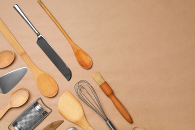 Set of modern cooking utensils on brown background, flat lay. Space for text