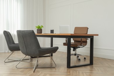 Photo of Director's office with large wooden table and comfortable armchairs. Interior design