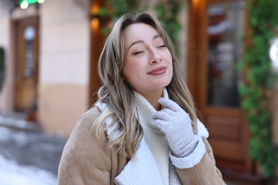 Photo of Portrait of charming woman on city street in winter