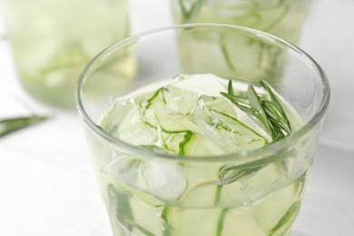 Photo of Glass of refreshing cucumber lemonade on table, closeup. Summer drink