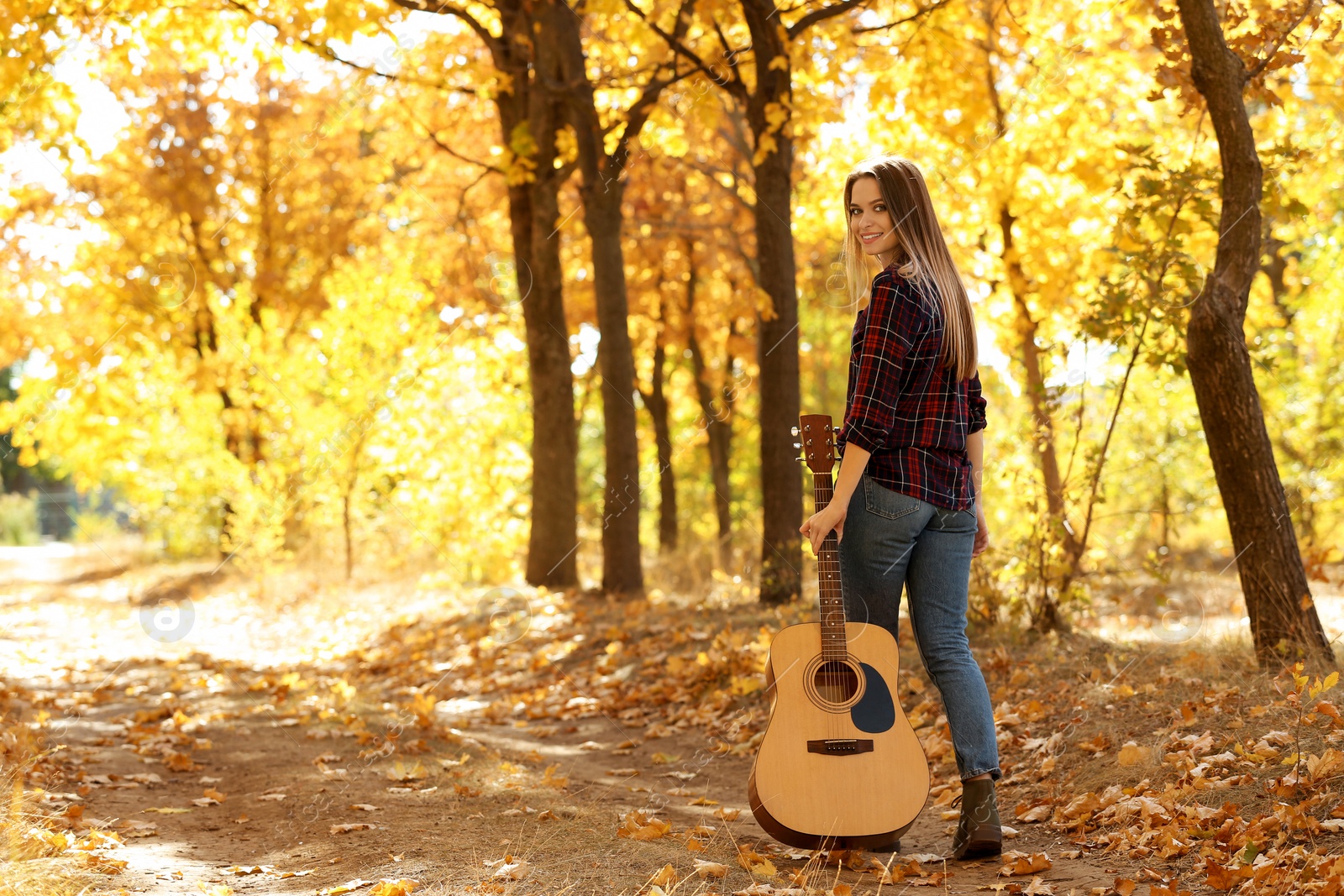 Photo of Teen girl with acoustic guitar in autumn park