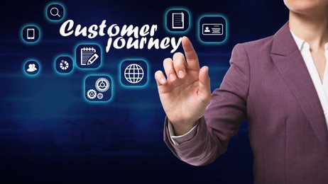 Customer journey concept. Woman pointing at virtual screen with different icons on dark background, closeup