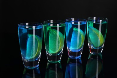 Alcohol drink with citrus wedges in shot glasses on mirror surface