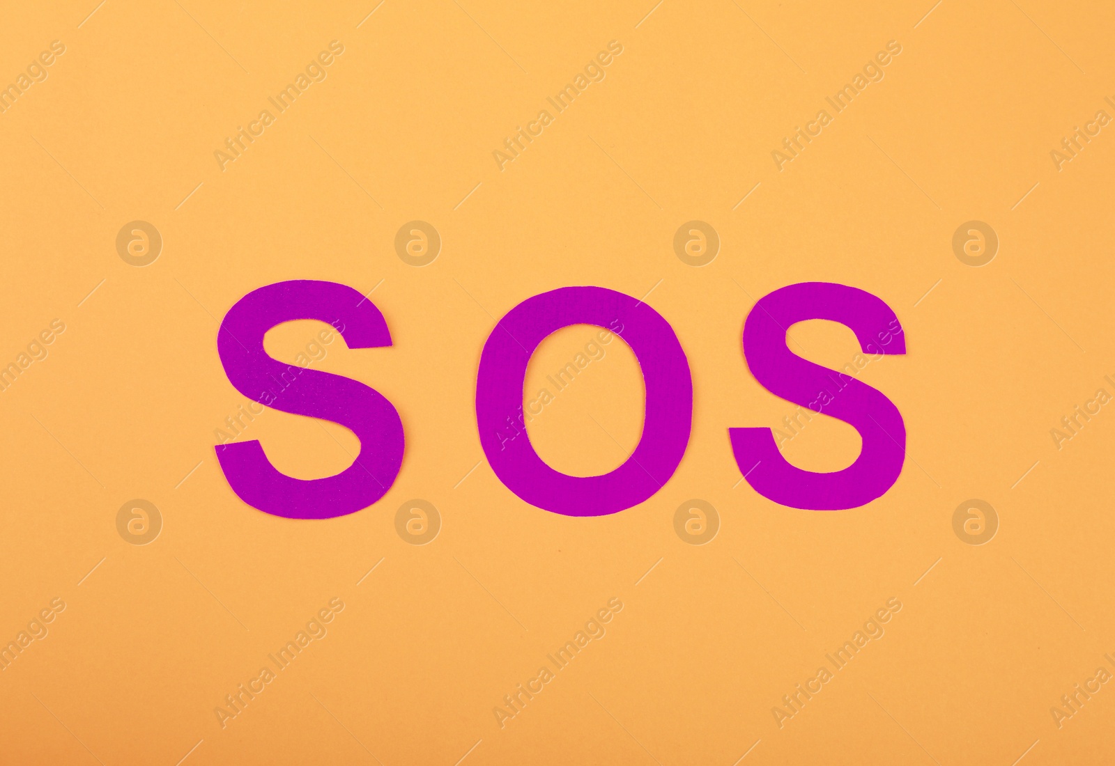 Photo of Abbreviation SOS made of paper letters on orange background, top view