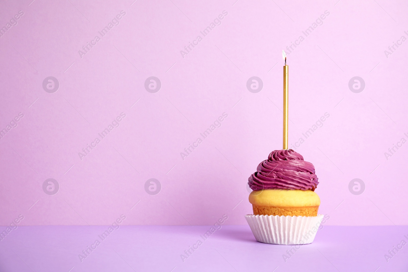 Photo of Birthday cupcake with candle on violet background, space for text