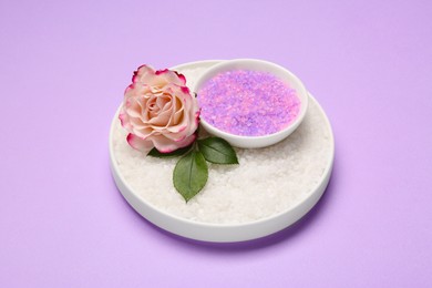 Photo of Aromatic sea salt and beautiful flower on purple background