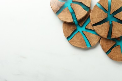 Stylish wooden cup coasters on white marble table, flat lay. Space for text