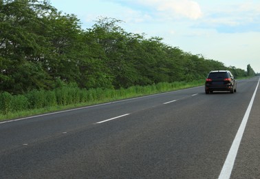 Photo of Black car on asphalt road in countryside