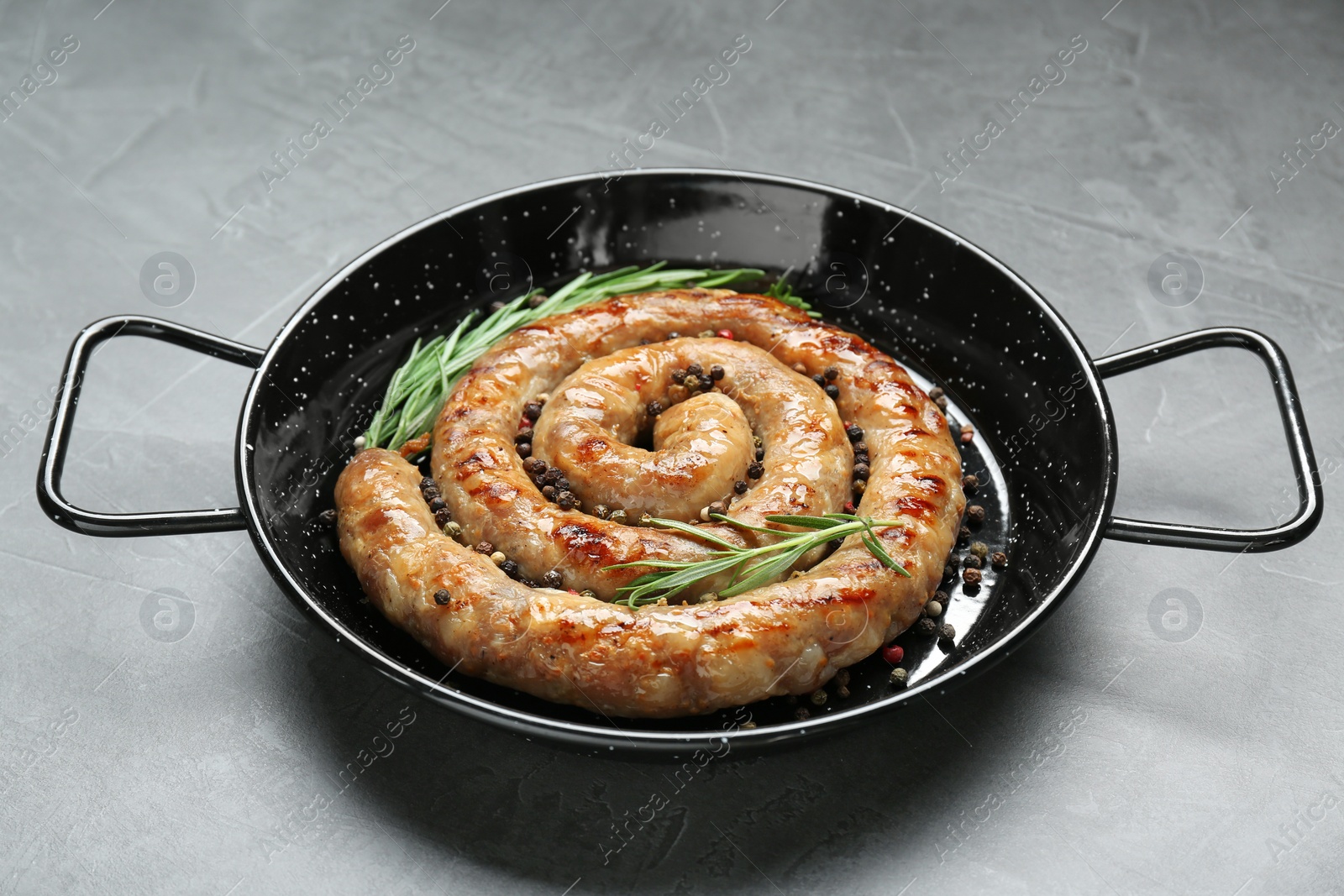 Photo of Tasty homemade sausages with spices on grey table