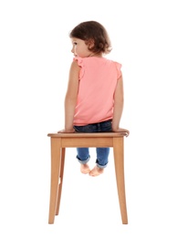 Photo of Little girl on stool against white background. Danger at home