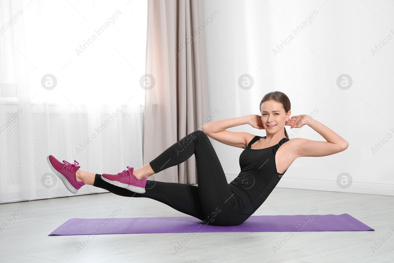 Photo of Young woman doing fitness exercises at home