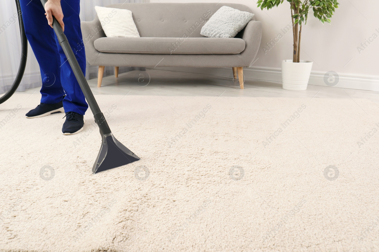 Photo of Man removing dirt from carpet with vacuum cleaner indoors, closeup. Space for text