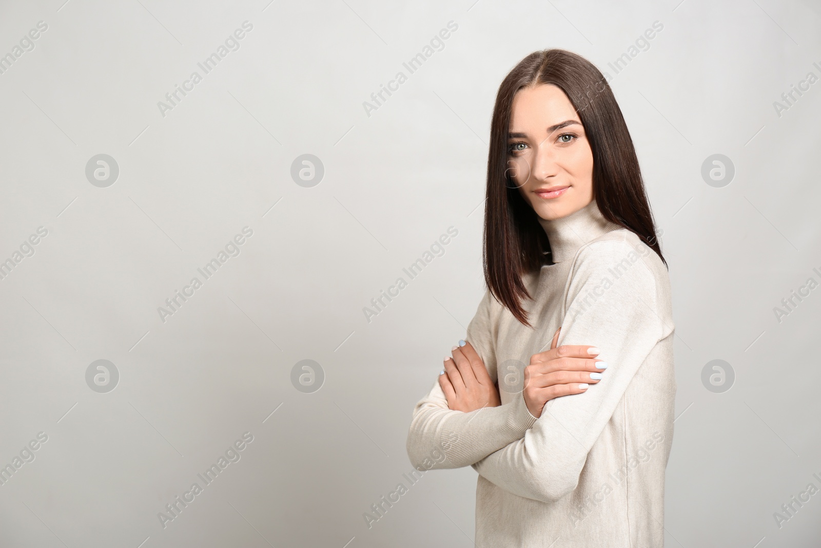 Photo of Portrait of pretty young woman with gorgeous chestnut hair on light background, space for text