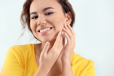 Photo of Beautiful young woman with acne problem on light background