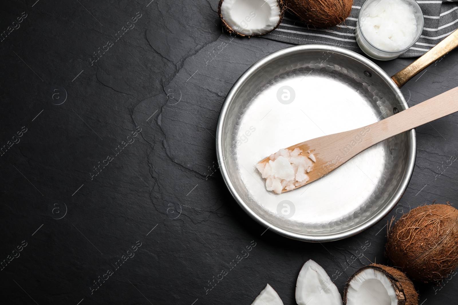 Photo of Flat lay composition with coconut oil and frying pan on black table, space for text. Healthy cooking