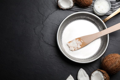 Photo of Flat lay composition with coconut oil and frying pan on black table, space for text. Healthy cooking