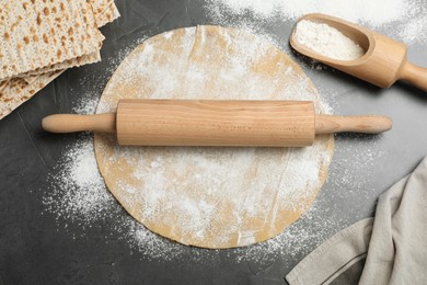 Photo of Matzos and raw dough on grey table, flat lay