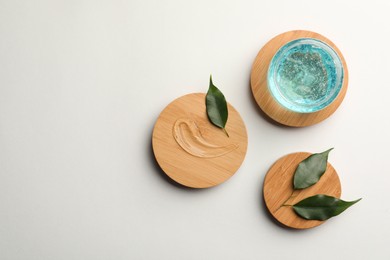 Photo of Flat lay composition with blue cosmetic gel and leaves on white background. Space for text