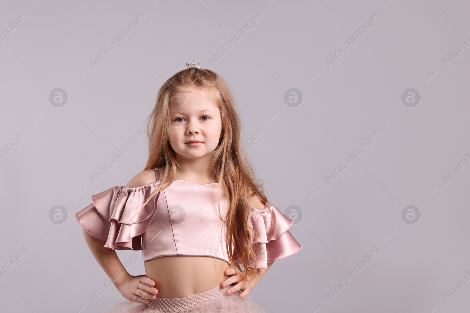 Photo of Cute girl in fairy dress with small crown on light grey background, space for text. Little princess