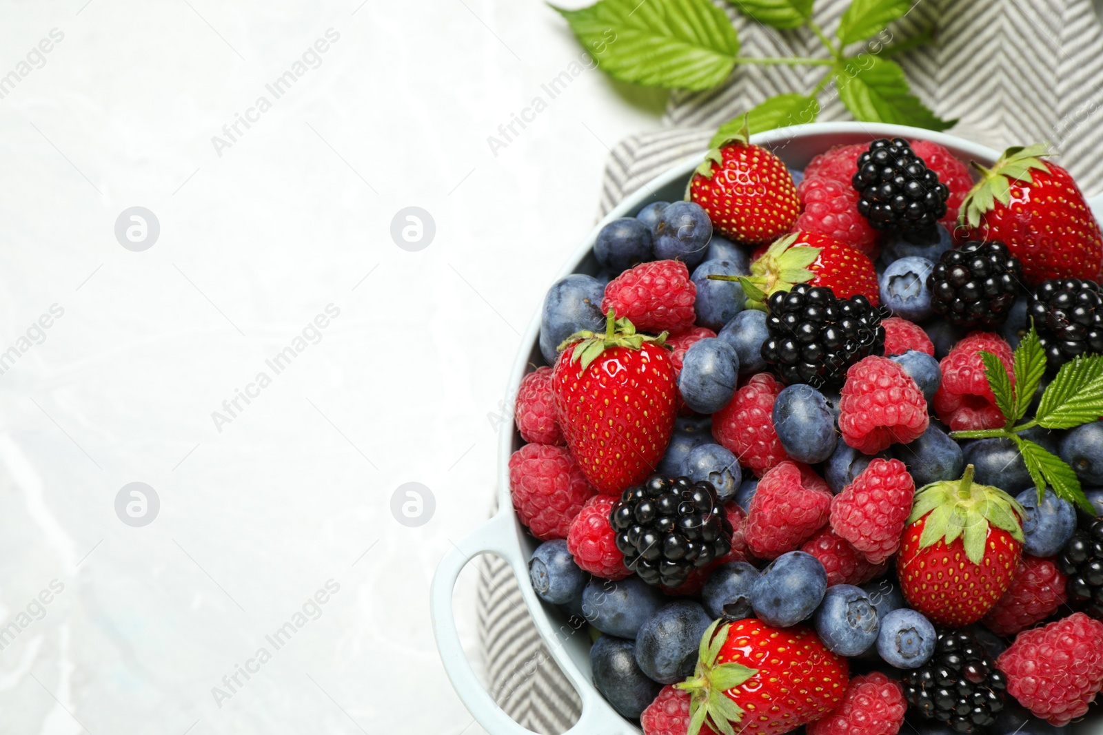 Photo of Mix of ripe berries on light table, flat lay. Space for text