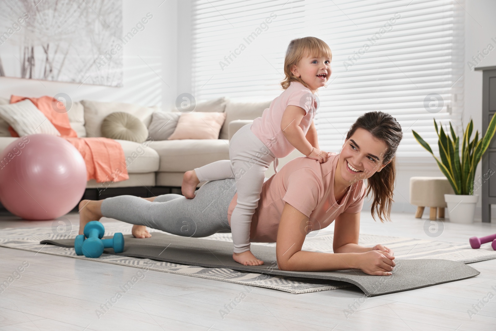 Photo of Mother doing exercise with her daughter at home