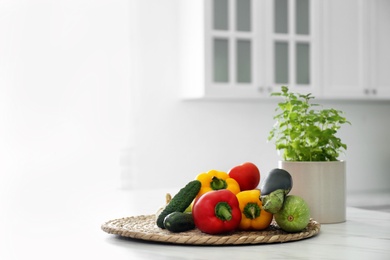 Different fresh vegetables on white table in modern kitchen. Space for text