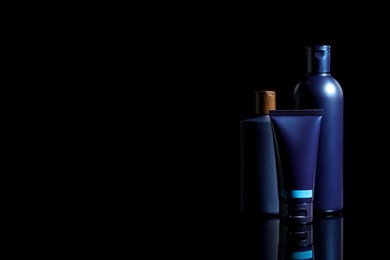 Photo of Facial cream and other men's cosmetic products on black background. Space for text