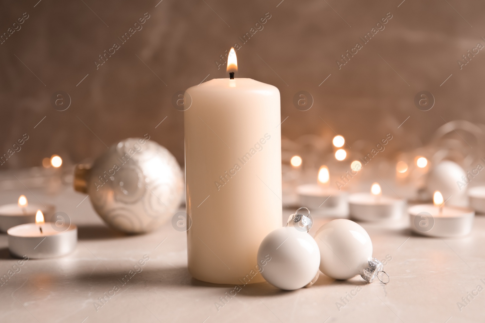 Photo of Burning wax candle and Christmas decorations on table