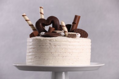 Delicious cake decorated with sweets on grey background, closeup