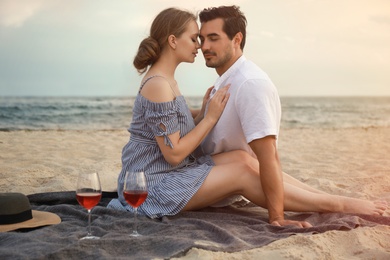 Happy young couple having picnic at sea beach