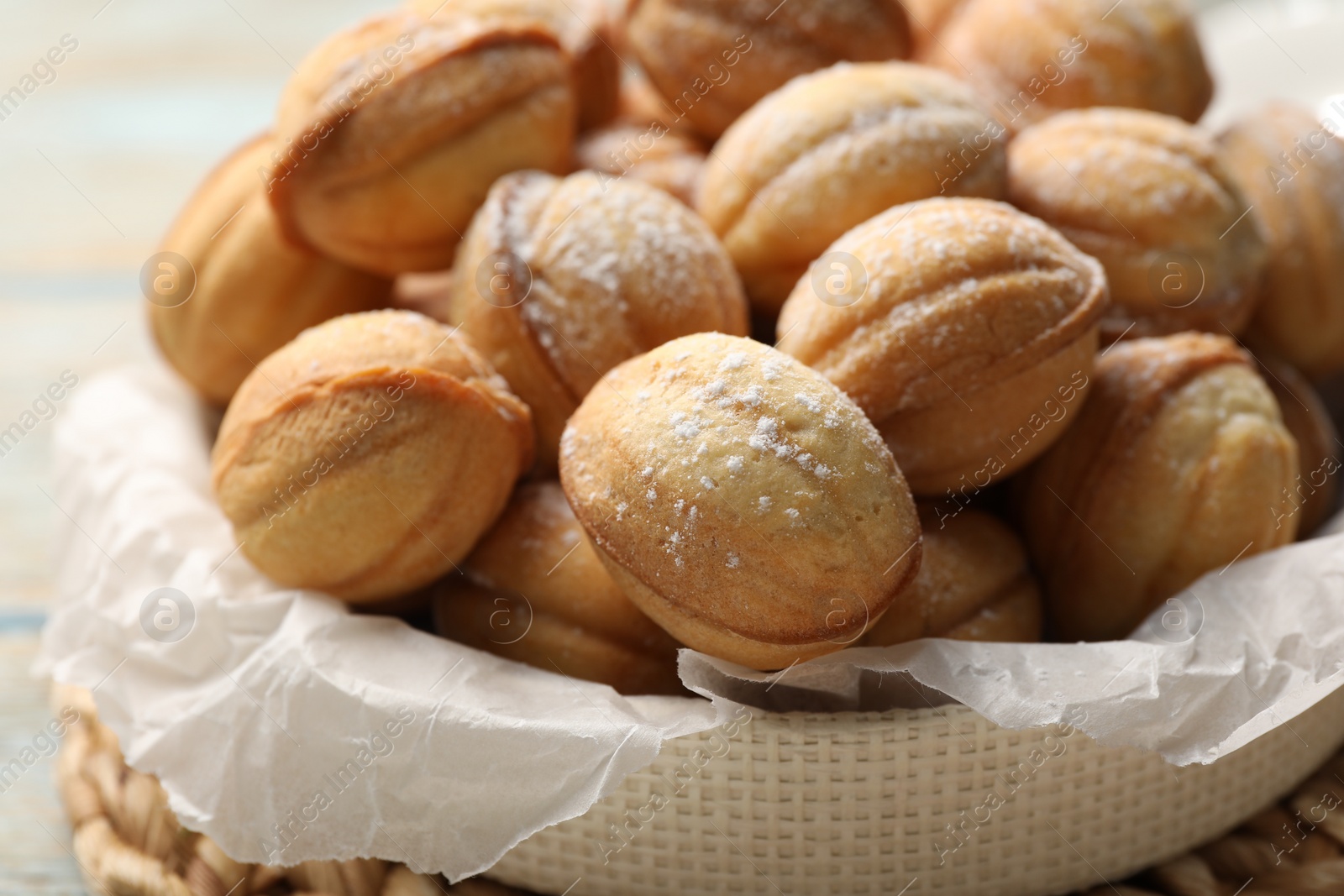 Photo of Bowl of delicious nut shaped cookies on grey wooden table, closeup