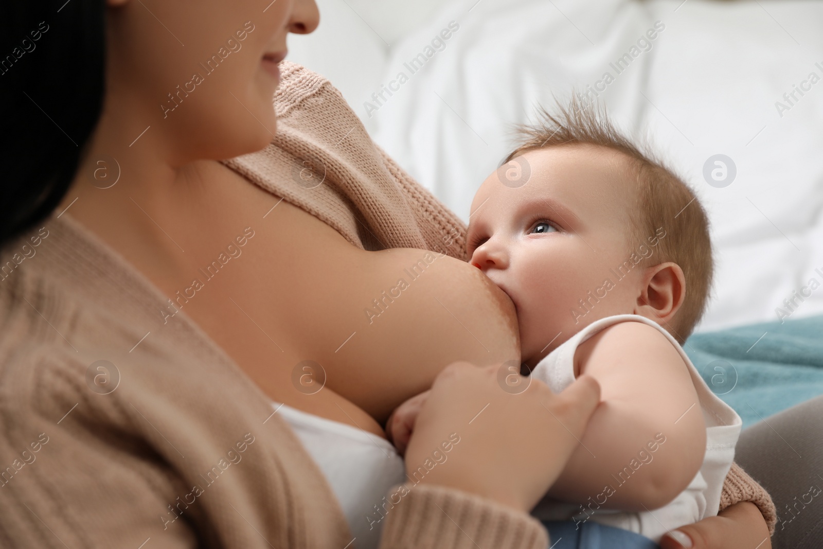 Photo of Woman breastfeeding her little baby at home