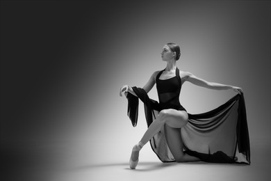 Graceful young ballerina practicing dance moves with veil, space for text. Black and white effect