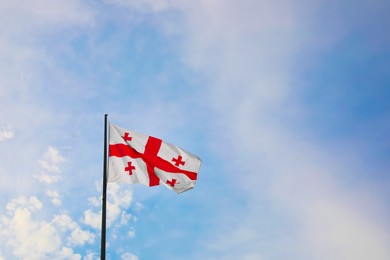 Photo of BATUMI, GEORGIA - MAY 31, 2022: Flag of Georgia fluttering on pole outdoors, space for text