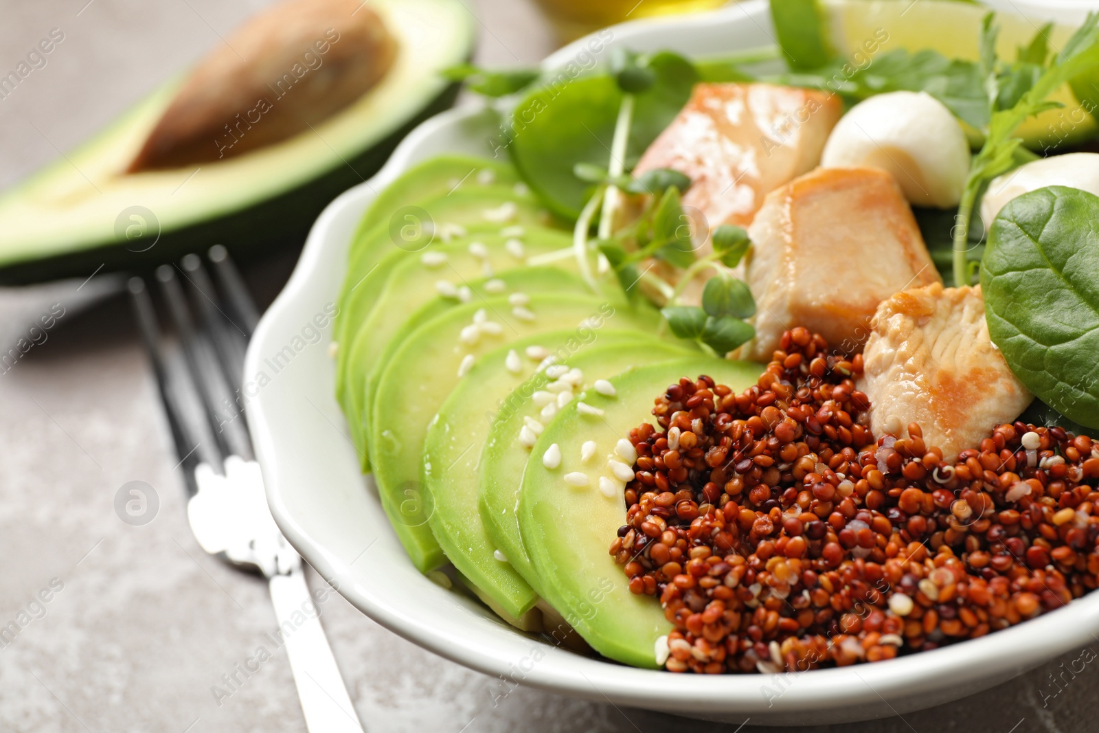 Photo of Delicious avocado salad with chicken on light grey marble table, closeup