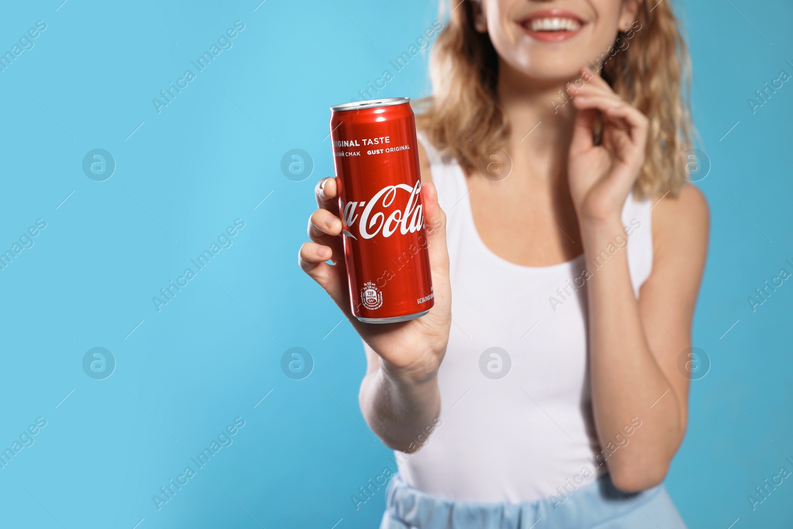 Photo of MYKOLAIV, UKRAINE - NOVEMBER 28, 2018: Young woman with Coca-Cola can on color background, space for text
