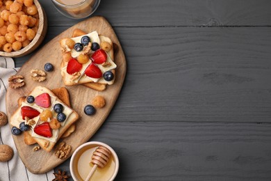 Tasty brie cheese sandwiches on grey wooden table, flat lay. Space for text