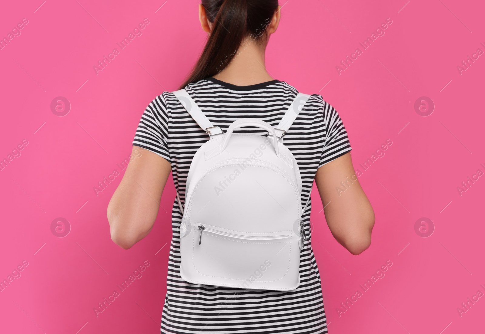 Photo of Young woman with stylish leather backpack on pink background, back view