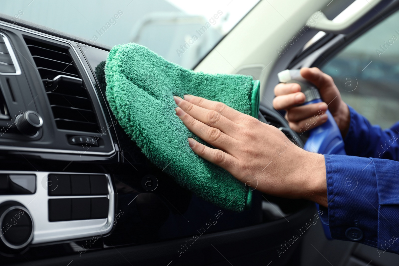 Photo of Car wash worker cleaning automobile interior, closeup