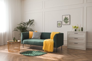 Stylish living room interior with comfortable green sofa