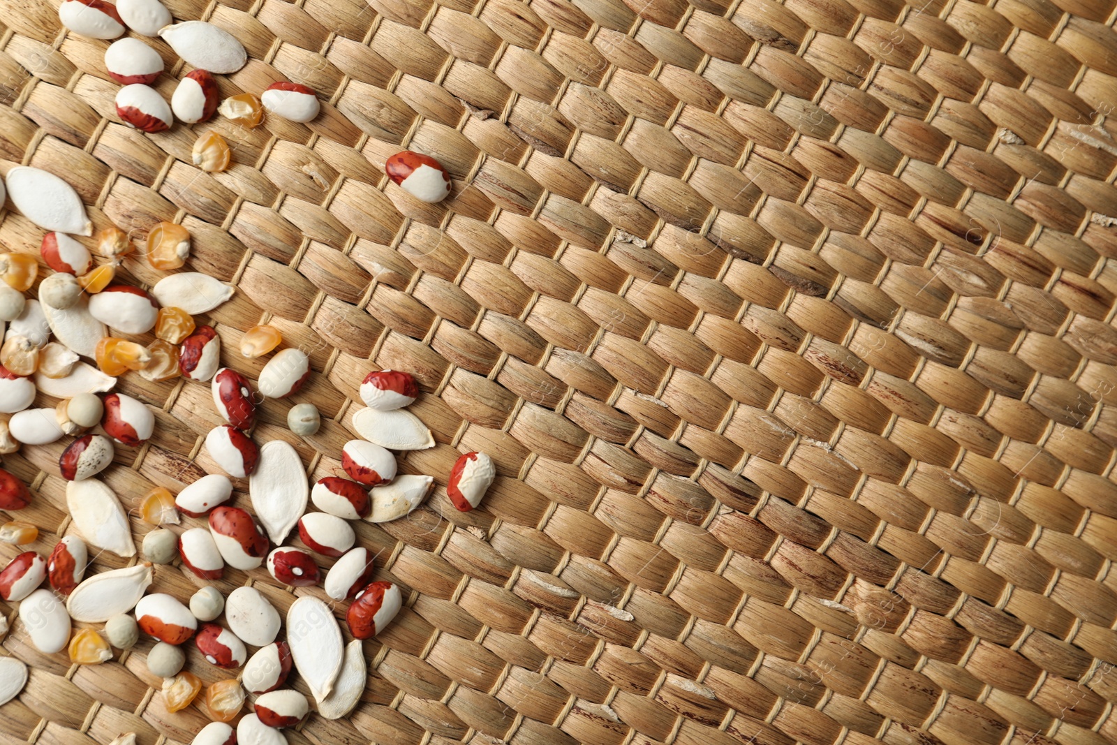 Photo of Mixed vegetable seeds on wicker background, flat lay. Space for text