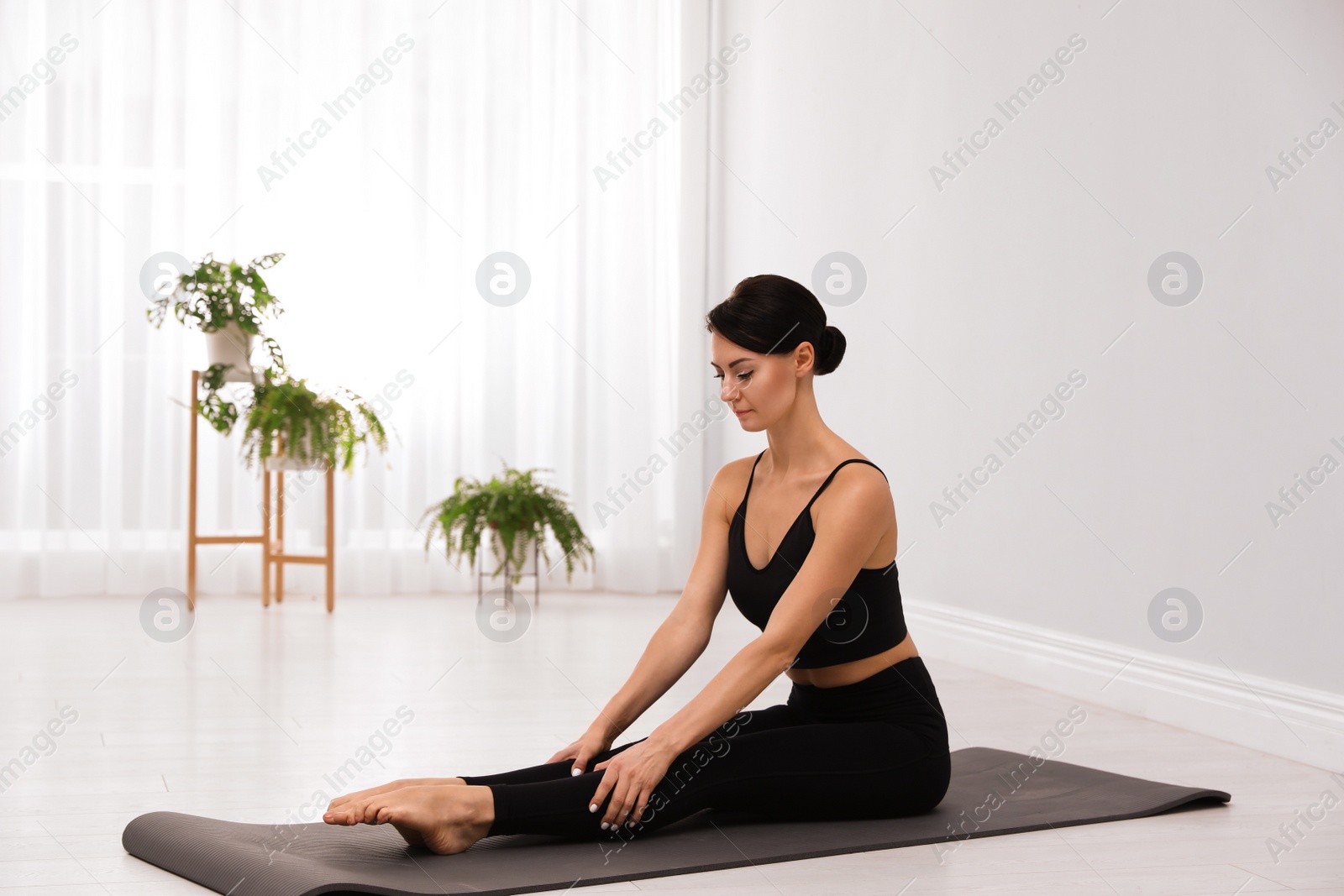 Photo of Professional young acrobat practicing yoga at home