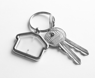 Photo of House keys with trinket on white background