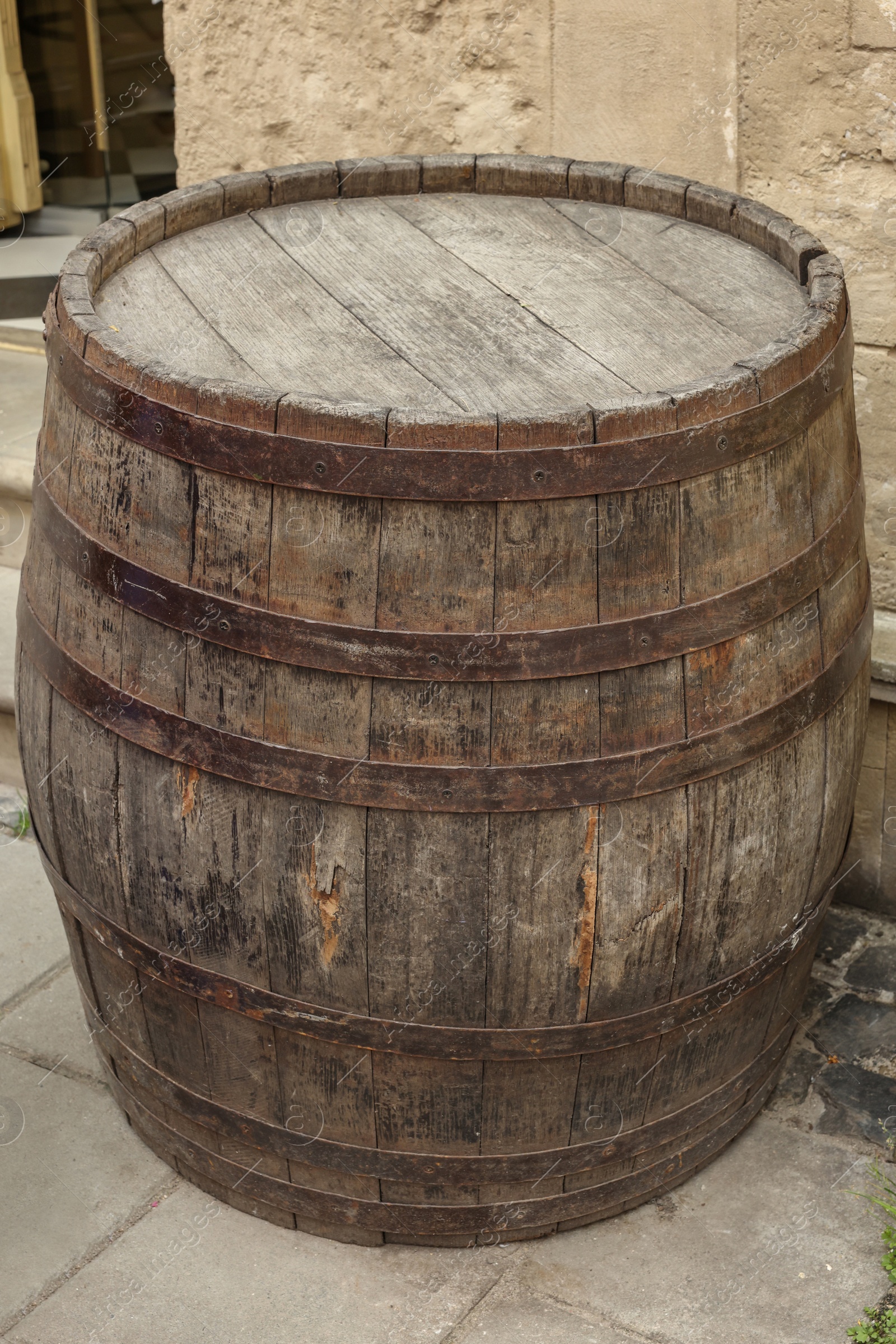 Photo of Traditional wooden barrel on street outdoors. Wine making