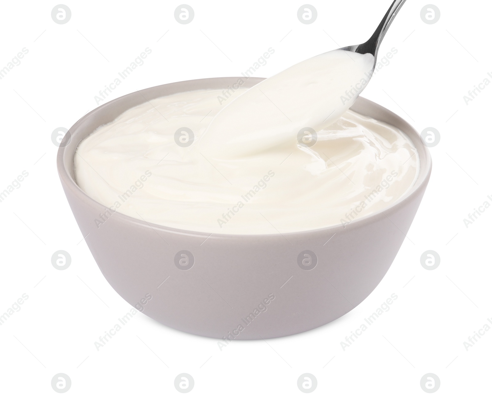 Photo of Ceramic bowl and spoon with delicious organic yogurt on white background