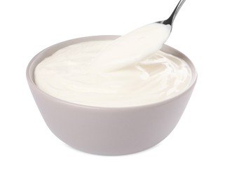 Photo of Ceramic bowl and spoon with delicious organic yogurt on white background