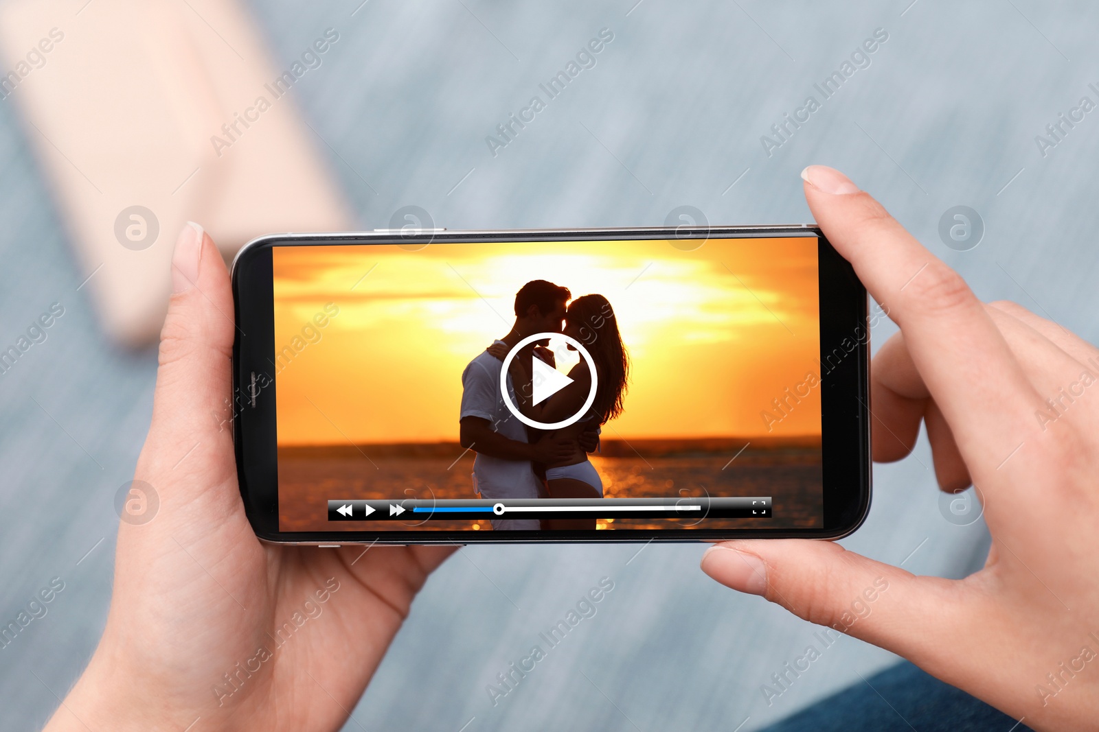 Image of Woman watching video on mobile phone, closeup