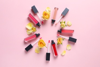 Photo of Composition of lipsticks with flowers on color background, flat lay.