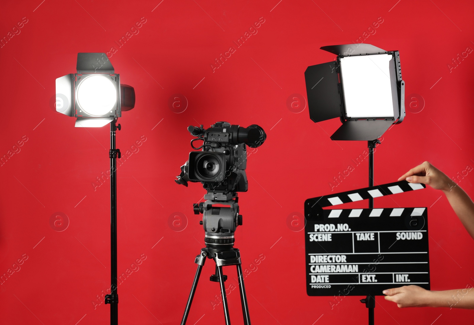 Photo of Woman with clapperboard near video camera in studio, closeup